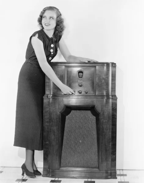 stock image Woman next to a radio turning the knobs