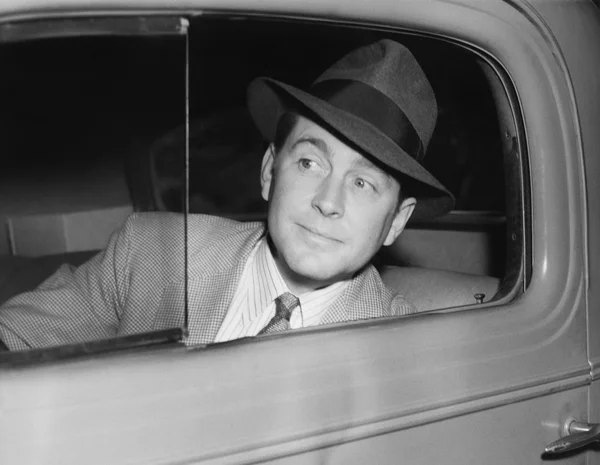 Мужчина, сидящий в машине и смотрящий в окно — стоковое фото