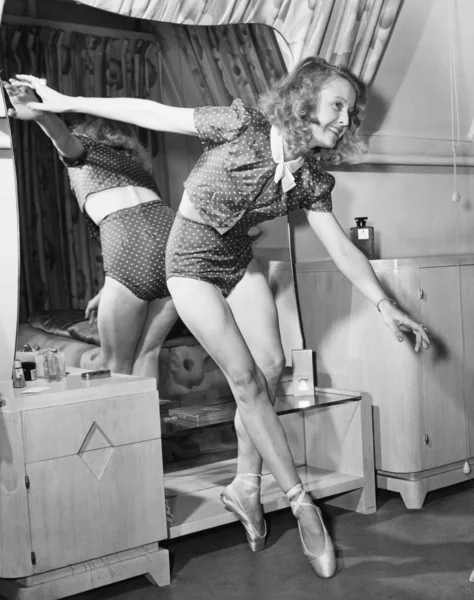 Женщина в туфлях балерины танцует перед зеркалом — стоковое фото