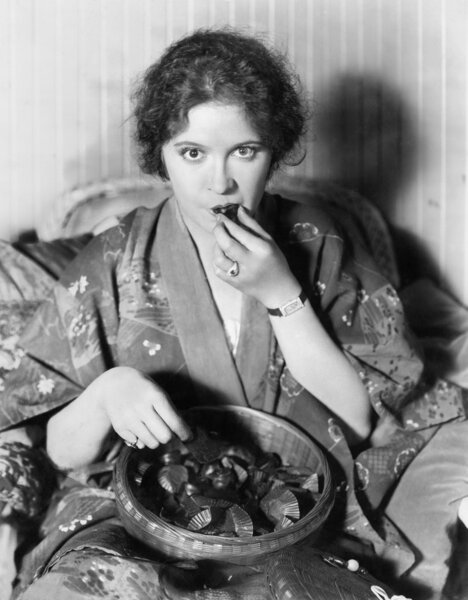 Женщина ест шоколад из миски
