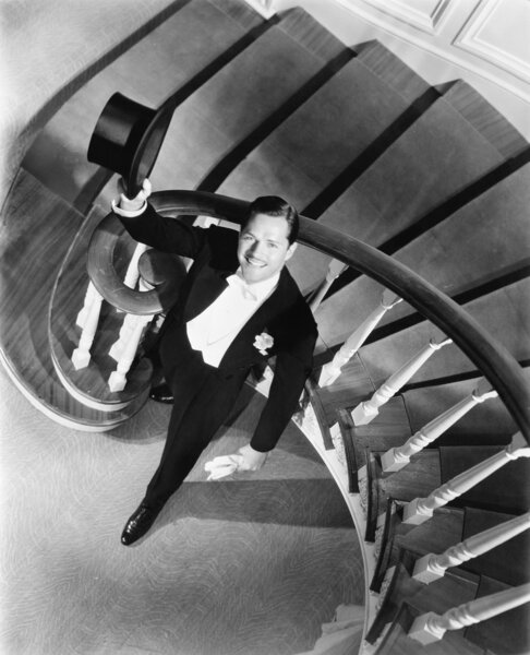 Elegant man looking up from the bottom of a staircase