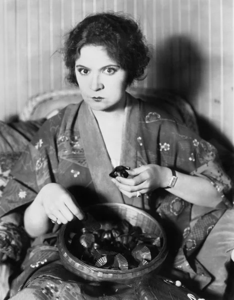 Donna che mangia cioccolatini da una ciotola — Foto Stock