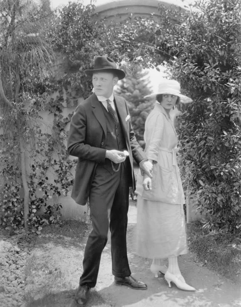 Marido parando sua esposa para continuar andando pelo jardim — Fotografia de Stock