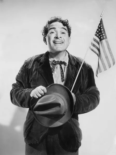Человек с американским флагом в руке улыбается — стоковое фото