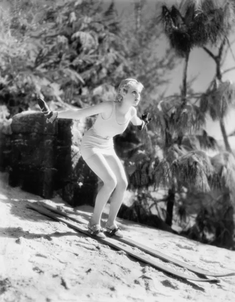Женщина в купальнике катается на лыжах с холма — стоковое фото