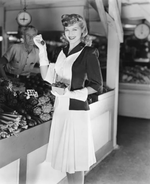 Γυναίκα σε μια αγορά μαζεύοντας φράουλες — Φωτογραφία Αρχείου