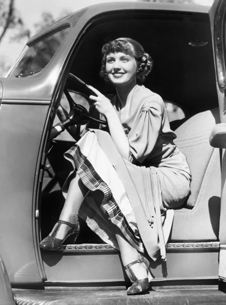 Mujer sentada en un coche detrás del volante — Foto de Stock