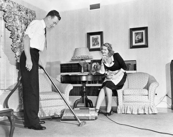 Vendedor demonstra um aspirador de pó para uma dona de casa em sua casa — Fotografia de Stock