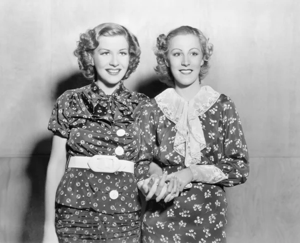 Две молодые женщины стоят вместе и держатся за руки — стоковое фото