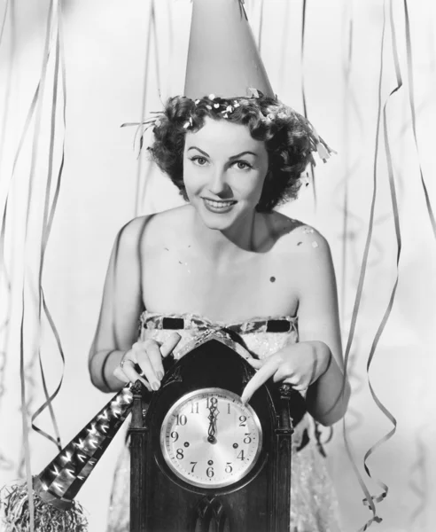 Mujer señalando el reloj a medianoche — Foto de Stock