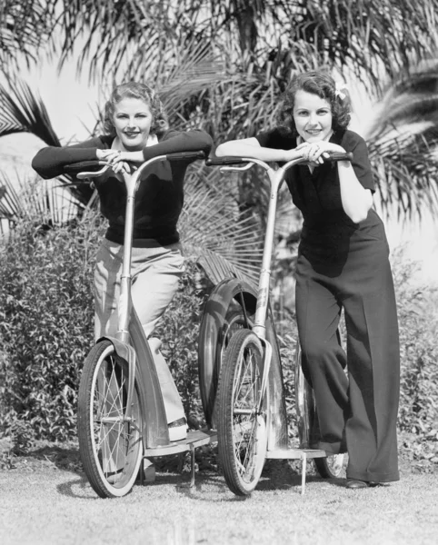 Duas mulheres de pé em suas scooters — Fotografia de Stock