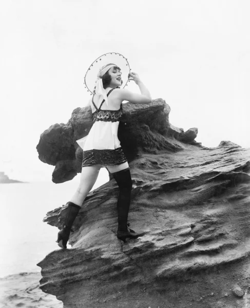 Donna in lingerie appoggiata su una roccia vicino all'acqua — Foto Stock