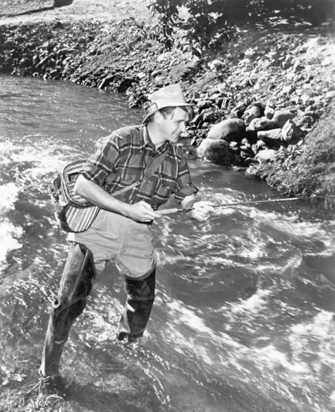 Hombre de pie en un arroyo de pesca de agua — Foto de Stock