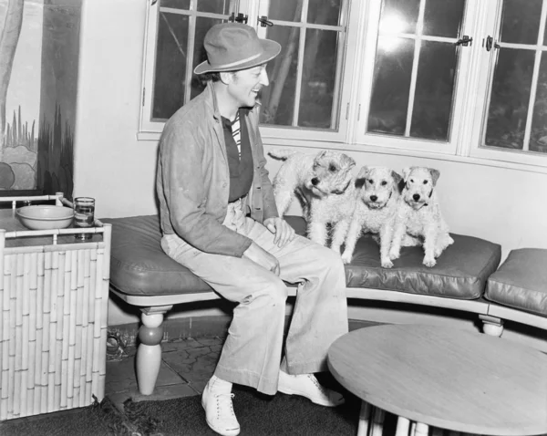 Ο άνθρωπος που κάθεται σε ένα παγκάκι με τρία σκυλιά του — Φωτογραφία Αρχείου