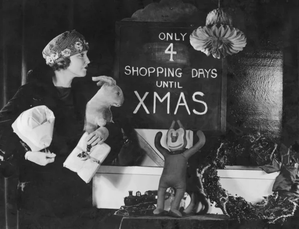 Kadın işaret Noel'e kadar alışveriş gün sayısı ile okuma — Stok fotoğraf