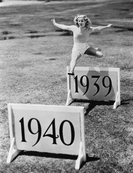 Mujer saltando vallas etiquetadas con años —  Fotos de Stock
