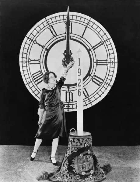 Femme avec bougie et horloge la veille du Nouvel An — Photo