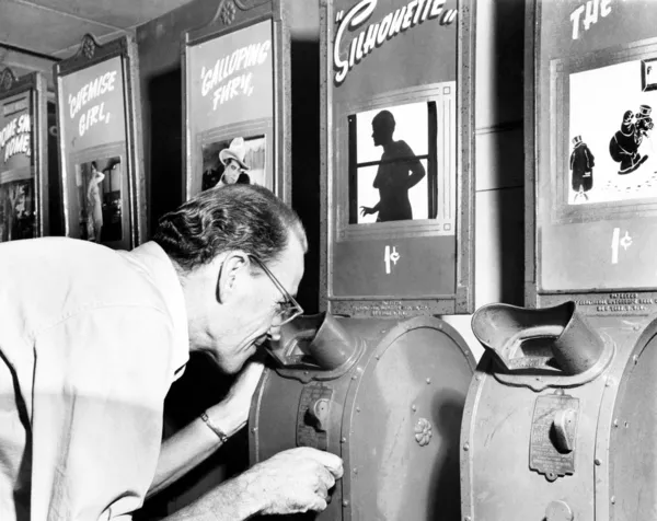 Mężczyzna patrząc na maszynę filmie nickelodeon — Zdjęcie stockowe