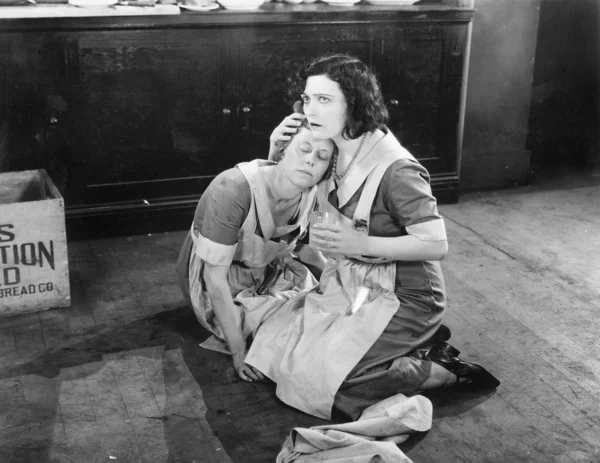 Δύο γυναίκες που κάθεται στο πάτωμα, ενώ κάποιος κρατάει την άλλη — Φωτογραφία Αρχείου