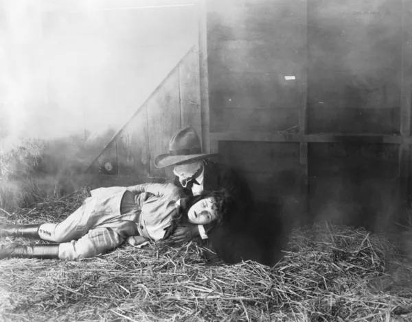 Man rescuing woman from fire in barn — Stock Photo, Image