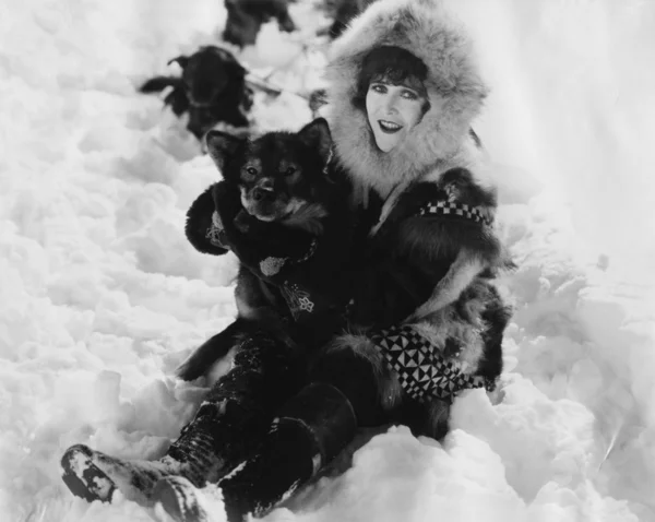 Mulher e cão brincando na neve — Fotografia de Stock