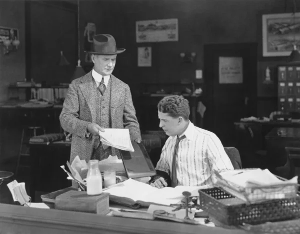 Mann mit Haltung zeigt Büroangestellten Papiere — Stockfoto