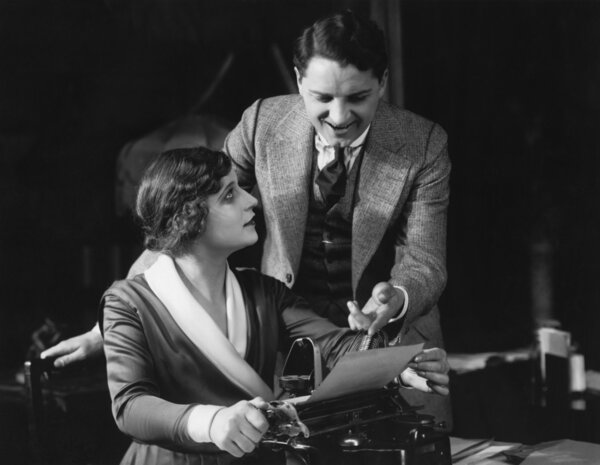 Secretary looking at smiling manager