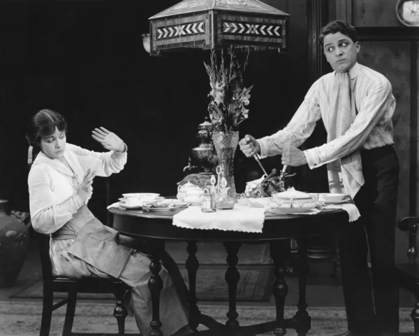 Korkunç kadın izlerken adam bıçaklama Zeytinyağlı bir yemek masası üzerinde — Stok fotoğraf