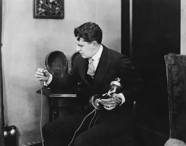 Άνθρωπος εξετάζοντας σπασμένα τηλεφωνικό καλώδιο — Φωτογραφία Αρχείου