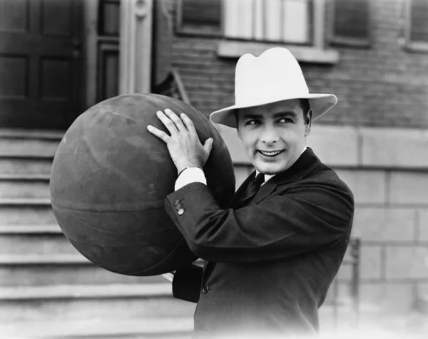 Uomo in cappello in possesso di grande palla — Foto Stock