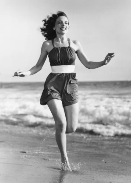 ビーチで実行されている陽気な若い女性 — ストック写真