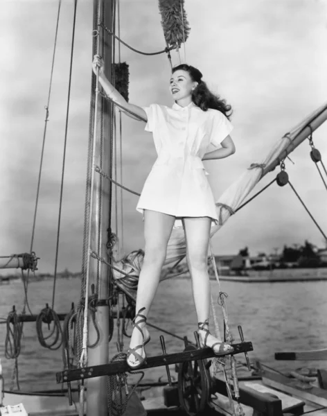 Usmívající se žena na lodi drží stožár — Stock fotografie