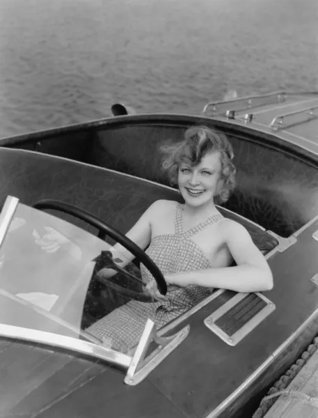 Direksiyon simidi, motorlu teknenin arkasındaki kadın — Stok fotoğraf