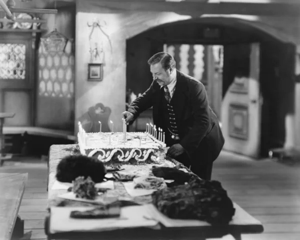 Homem acendendo velas no bolo — Fotografia de Stock