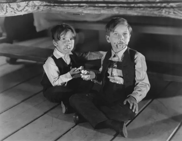 Jovens meninos comendo bolo ser pego no ato — Fotografia de Stock