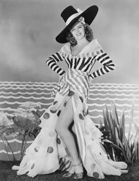 Жінка позує в смугастому і багатокольоровому костюмі — стокове фото