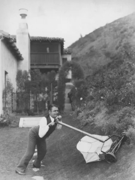 Muž snaží sekat trávník — Stock fotografie