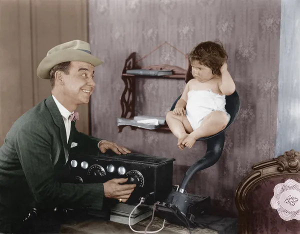 Father with baby in speaker horn of old radio — Stock Photo, Image