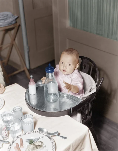 Bebek mama sandalyesi ile büyük ve küçük şişeler içinde — Stok fotoğraf