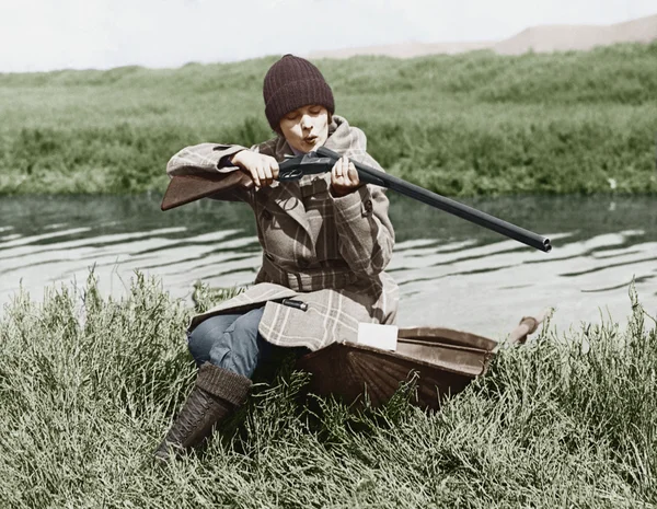 Охотница с пистолетом возле реки — стоковое фото