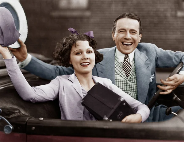 Porträtt av lyckliga par viftande i bil — Stockfoto