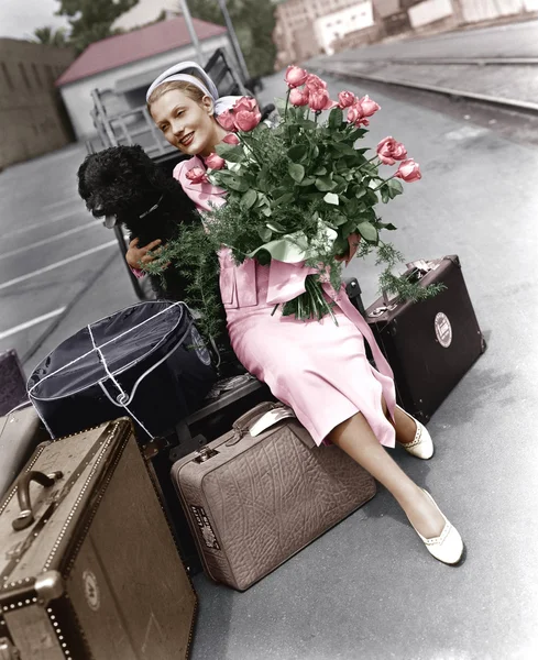 Woman with luggage flowers and dog — Stock Photo, Image