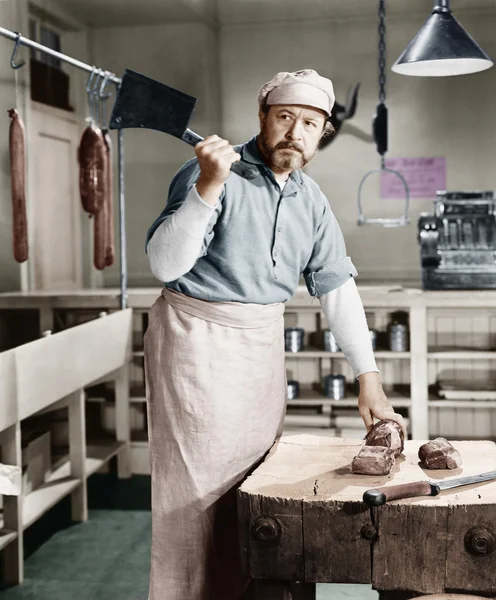 Macellaio che taglia carne con mannaia — Foto Stock