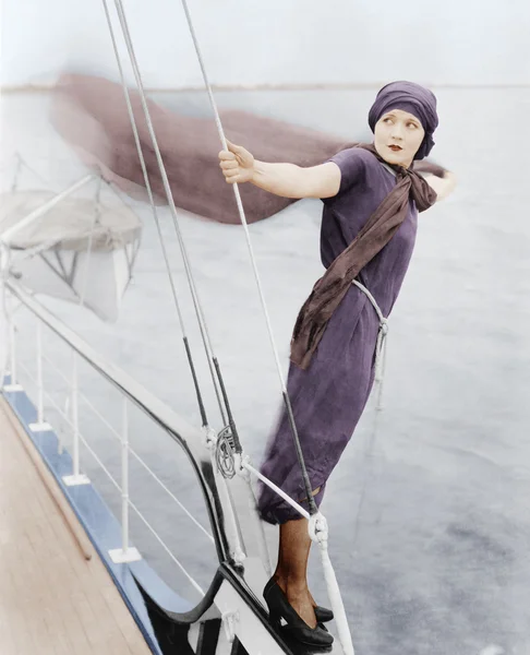 Woman leaning off boat into the wind — Stock Photo, Image