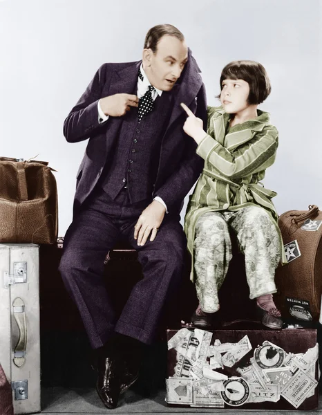 Far och dotter sitter tillsammans på bagage — Stockfoto
