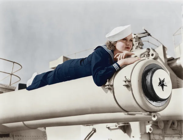 Mulher de uniforme de marinheiro deitada num canhão — Fotografia de Stock