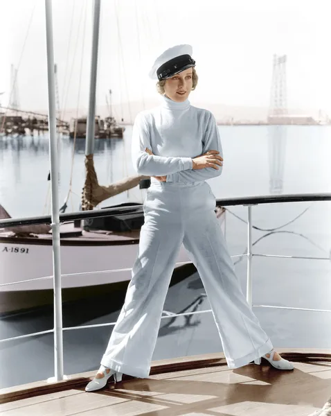 Vrouw in een kapiteins hoed staande op de top van een zeilboot — Stockfoto