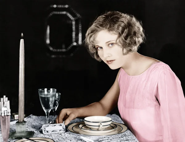Kvinna sitter vid matbordet — Stockfoto