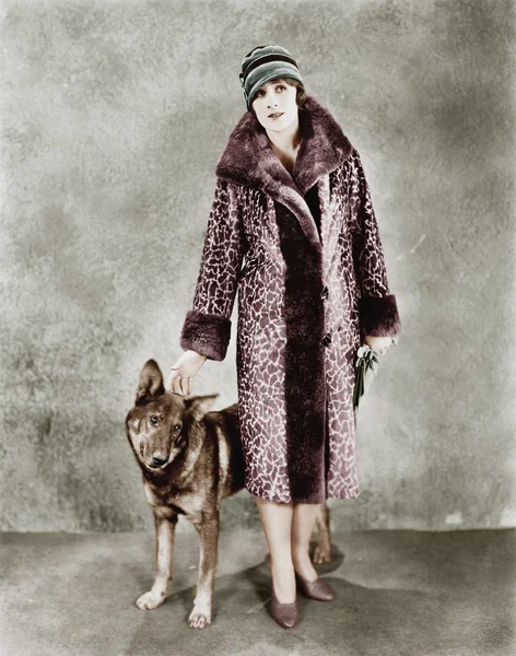 Nő a zsiráf mintás prémes kabátját és a kutyája — Stock Fotó
