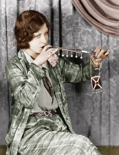 Mujer joven fumando un cigarrillo con una extensión de cigarrillo —  Fotos de Stock